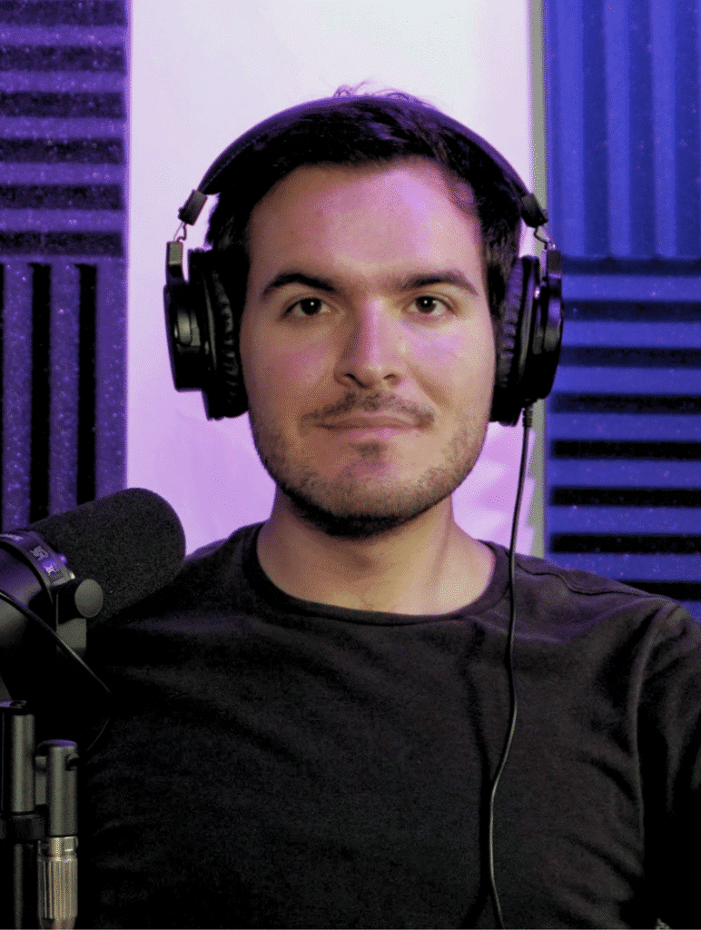 Productor de podcast con audífonos y micrófono profesional en estudio insonorizado.
